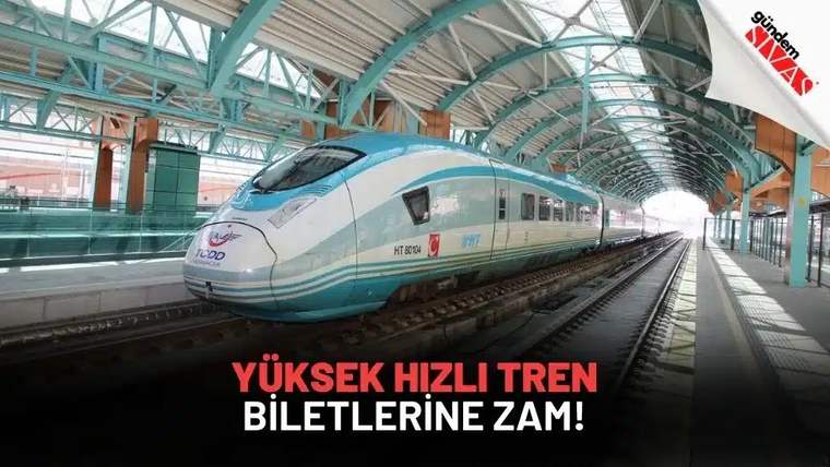 Mavi-beyaz renkte bir yüksek hızlı tren, raylar üzerinde duruyor.