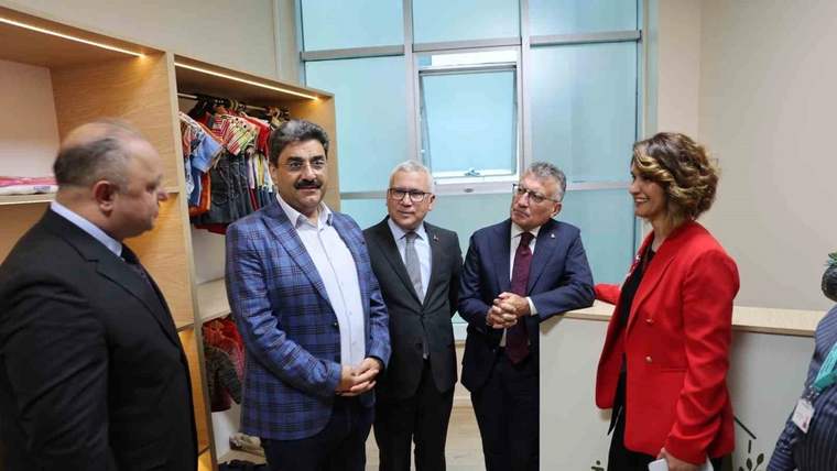 Giysi dolabının önünde, biri kırmızı ceketli beş kişi yan yana duruyor.