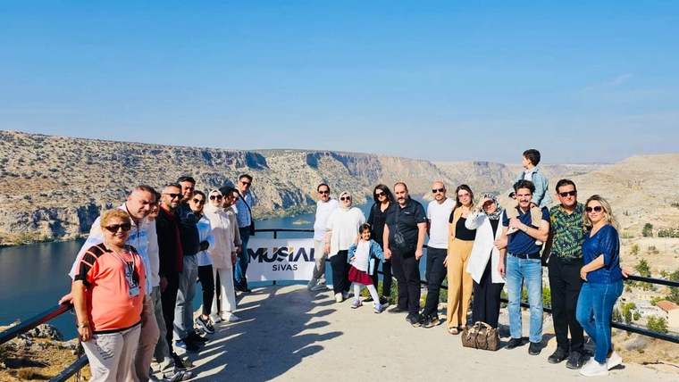MÜSİAD Sivas yazılı pankartın önünde duran kalabalık grup, kayalık vadinin seyir noktasında görülüyor.
