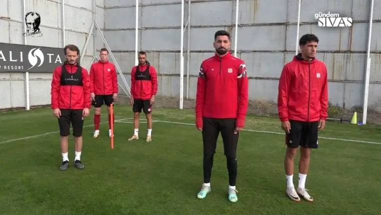 Antrenman sahasında, Sivasspor futbolcuları saygı duruşunda duruyor.