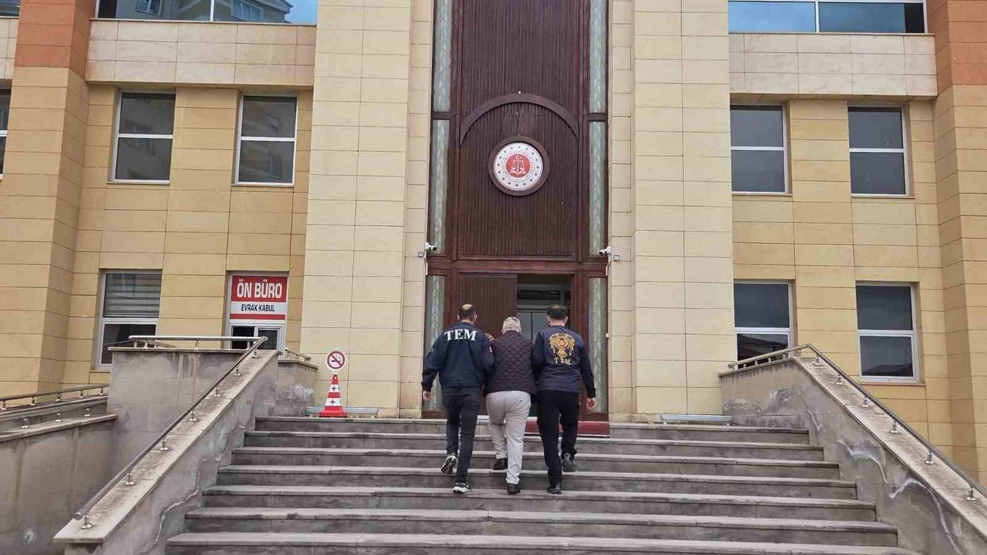 Merdivenlerden adliye girişine çıkan üç kişi görülüyor; birinin montunda “TEM” yazısı bulunuyor.