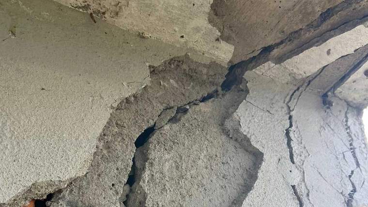 Duvar yüzeyinde büyük bir çatlak görünmekte, çatlak derin ve geniş.