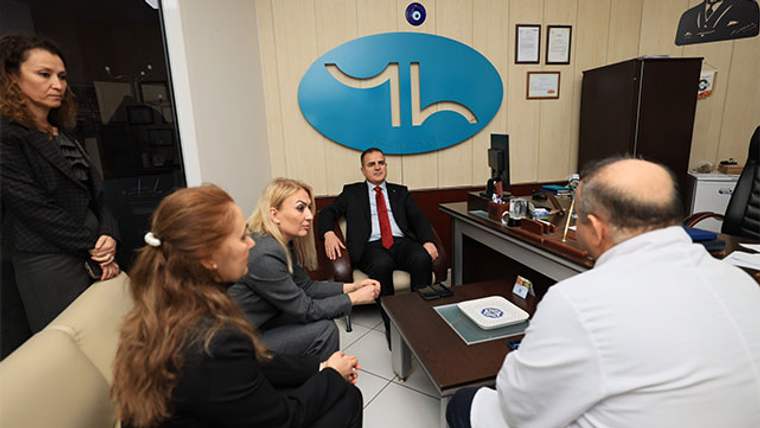 Bir hastane odasında, vali ve yanındaki kişiler doktorla konuşuyor.