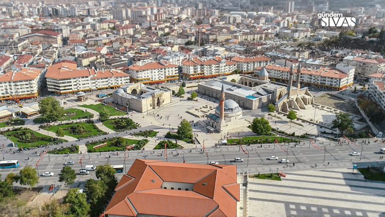Sivas'ın merkezinde yer alan tarihi bir cami ve çevresindeki binalar, yeşil alanlar ve yollar görünmektedir.