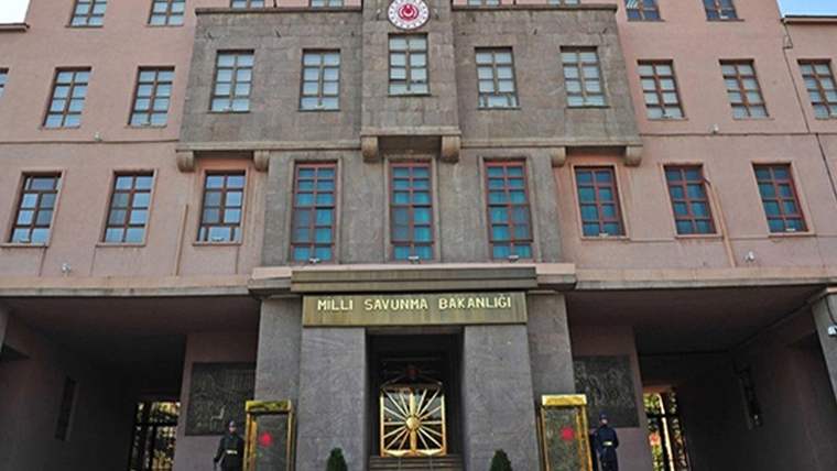 Üzerinde “Millî Savunma Bakanlığı” yazan binanın girişinde iki nöbet kulübesi ve bir görevli görülüyor.