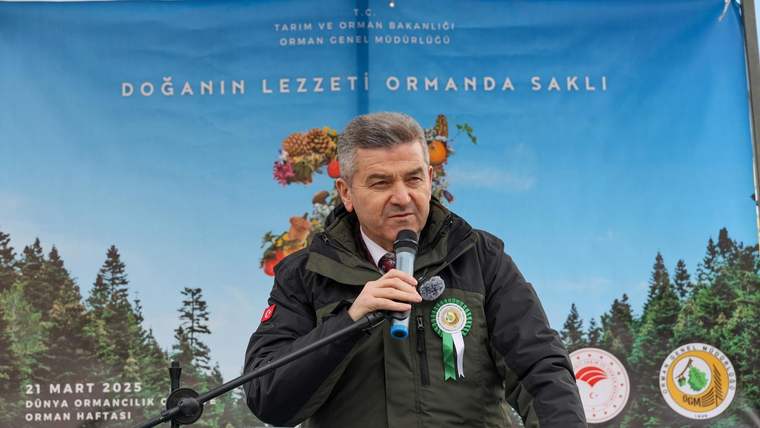 Mikrofonla kürsüde konuşan bir kişi, Orman Genel Müdürlüğü yazılı mavi pankartın önünde duruyor.