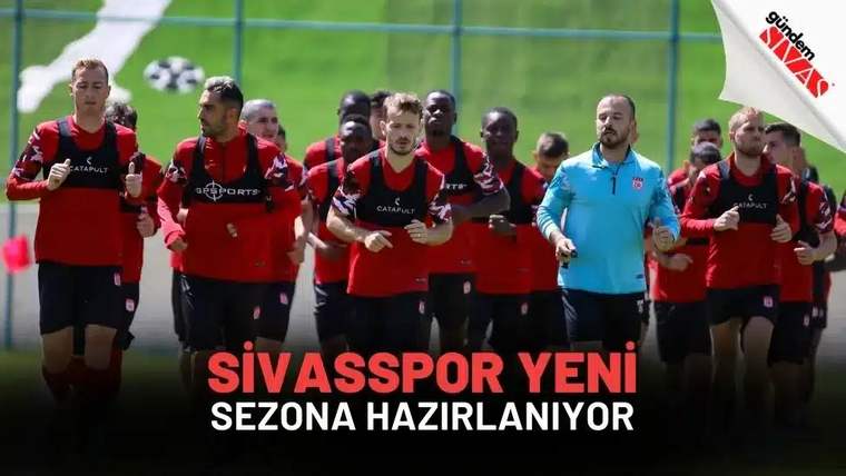 Kırmızı antrenman formaları giyen futbolcular, yeşil sahada yan yana koşarken görülüyor.