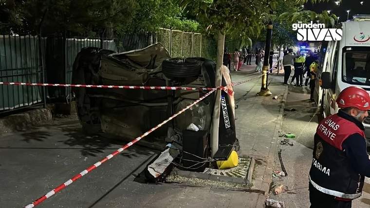 Yolda devrilmiş bir araç, çevresinde güvenlik şeridi ve polisler var.