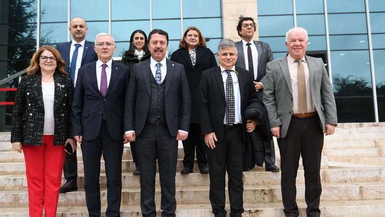 Başkent Üniversitesi ve Beypazarı Belediye Başkanı'nın bulunduğu bir grup insan, merdivenlerde poz veriyor.