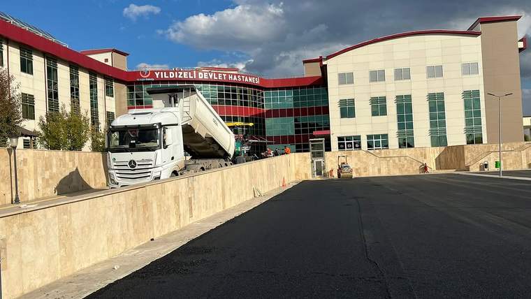 Yıldızeli Devlet Hastanesi önünde asfalt çalışması yapan bir kamyon, hastane binasının önünde duruyor.