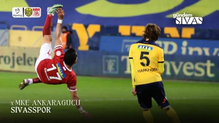 Kırmızı formalı futbolcu yerde düşerken, sarı formalı 5 numaralı futbolcu sahada ona bakıyor.