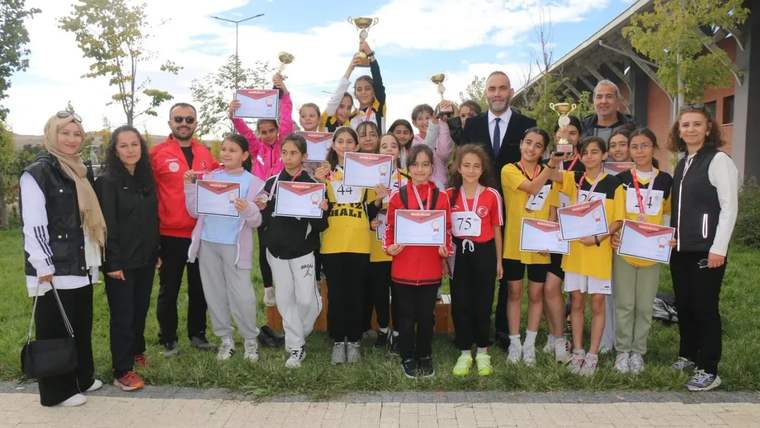 Ödül alan öğrenciler, kupa ve belgeleriyle birlikte poz veriyorlar.