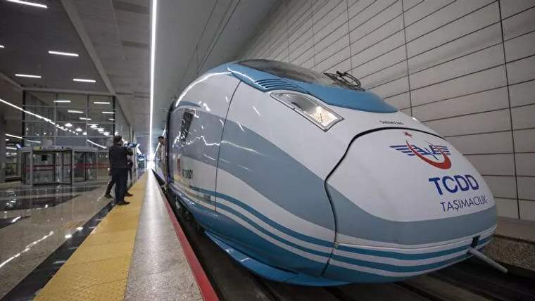 TCDD Taşımacılık yazılı yüksek hızlı tren, kapalı bir istasyonda platform kenarında duruyor.