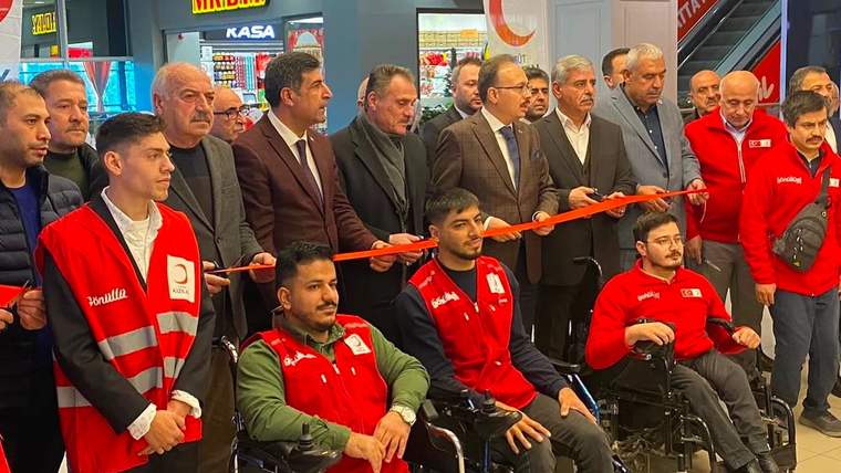 Kızılay görevlileri ve katılımcılar, bir açılışta kurdele kesme işlemi için bir araya gelmiş.