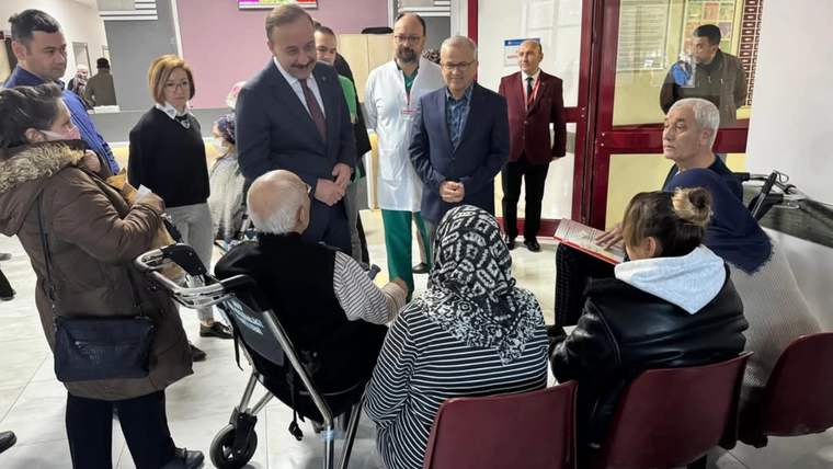 Hastane içinde, Vali Abdullah Erin ve sağlık çalışanları, hasta yakınlarıyla sohbet ediyor.