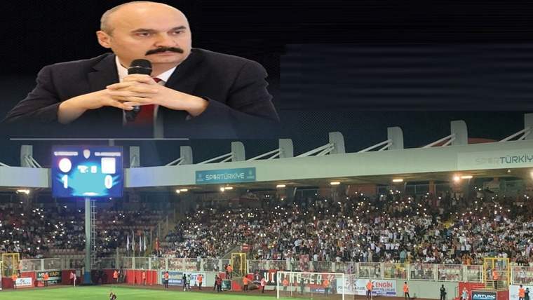 Mikrofon tutan takım elbiseli bir kişi ile ışıklandırılmış, tribünleri dolu bir futbol stadyumu görülüyor.