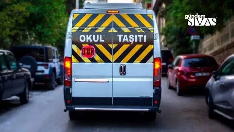 Arka tarafında "Okul Taşıtı" yazılı, sarı ve siyah şeritli bir minibüs, sokakta duruyor.