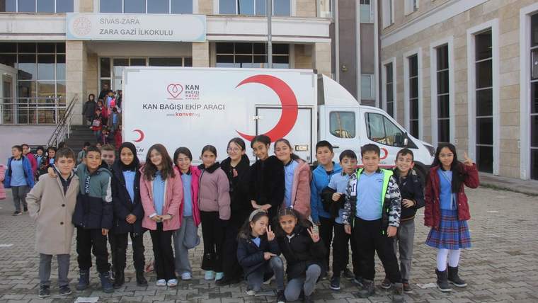 Zara Gazi İlkokulu önünde, kan bağışı kampanyasına katılan bir grup öğrenci poz veriyor.