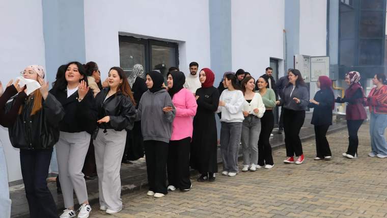 Nevruz kutlaması için sırada bekleyen genç kadınlar, çeşitli kıyafetler giymiş.