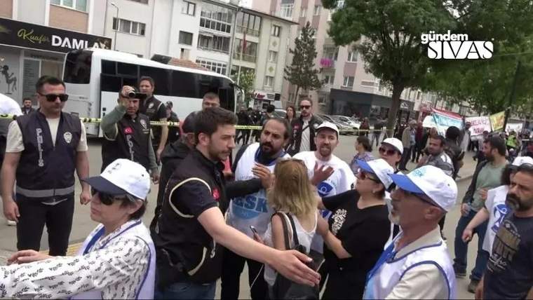 Gazetecilere yönelik sözlü saldırı sırasında kalabalık bir grup ve güvenlik güçleri görüntüleniyor.