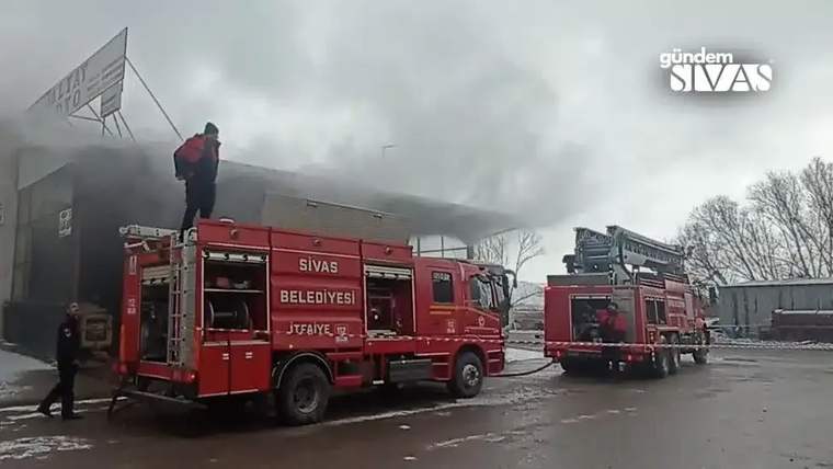 Sivas Belediyesi'ne ait itfaiye aracı, yangın söndürme çalışmaları için bir işyerinin önünde duruyor.