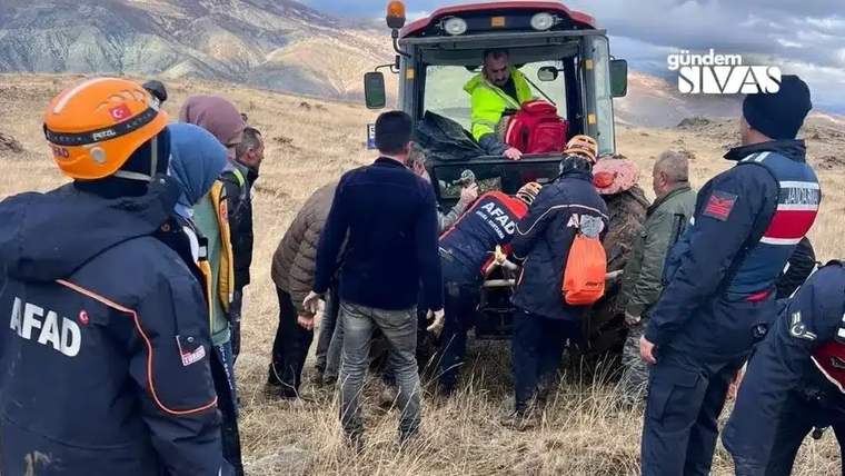 Dağlık arazide, AFAD yazılı kıyafetler giyen ekip üyeleri bir arazi aracının çevresinde duruyor.