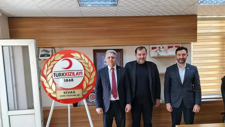 Türk Kızılay Sivas Şube Başkanlığı tabelası önünde ayakta duran üç erkek ve bir toplantı masası görülüyor.