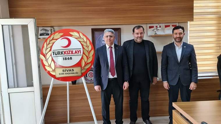 Türk Kızılay Sivas Şube Başkanlığı tabelası önünde ayakta duran üç erkek ve bir toplantı masası görülüyor.