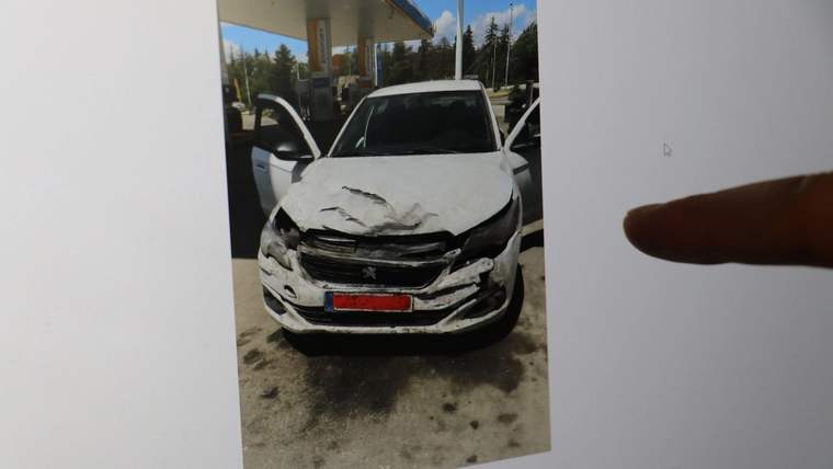Ön kısmı hasar görmüş bir otomobil, benzin istasyonunda duruyor.