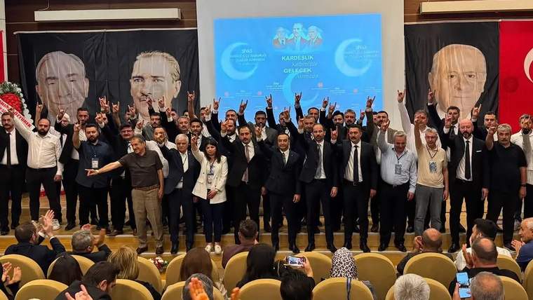 MHP Sivas Merkez İlçe Teşkilatı'nın toplantısında katılımcılar, ellerini havaya kaldırarak destek gösteriyor.