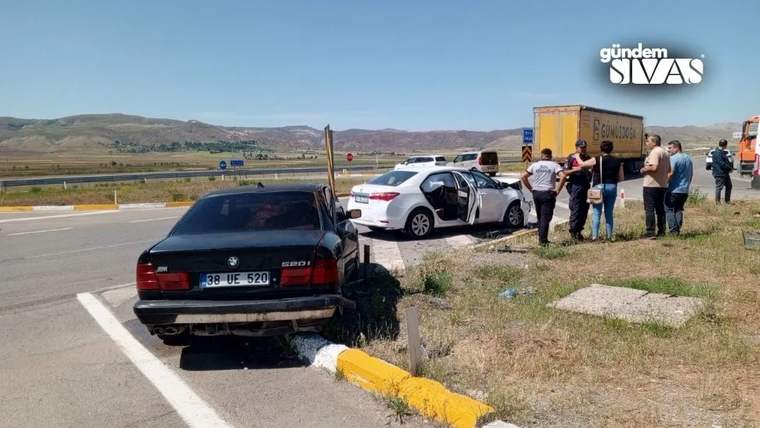 Yolda iki otomobilin çarpıştığı bir kaza anı, çevrede birkaç kişi bulunuyor.