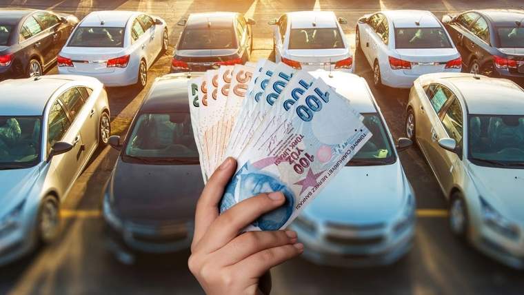 Park halindeki otomobillerin önünde, bir el farklı kupürlerde Türk lirası banknotlarını tutuyor.