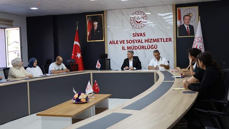 Sivas Aile ve Sosyal Hizmetler İl Müdürlüğü'nde toplantı yapan bir grup insan, masanın etrafında oturuyor.
