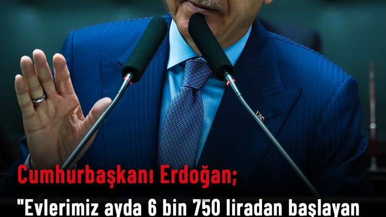 Kürsüde konuşan bir kişi, elini kaldırarak açıklama yapıyor.