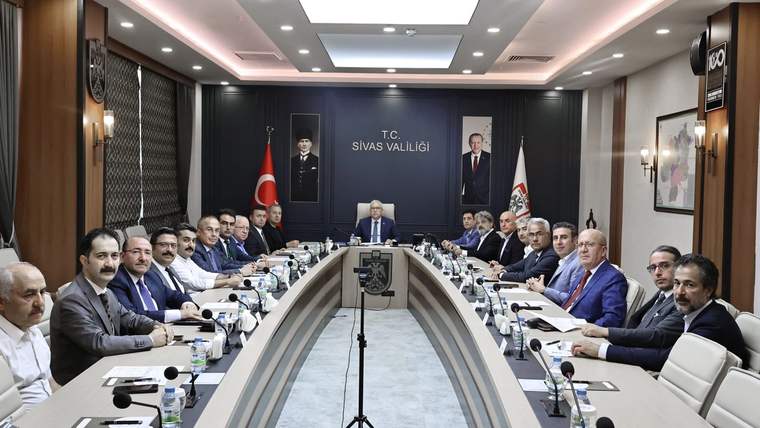 Toplantı salonunda uzun masanın çevresinde oturan kişiler, Türk bayrakları ve “T.C. Sivas Valiliği” yazısı görülüyor.
