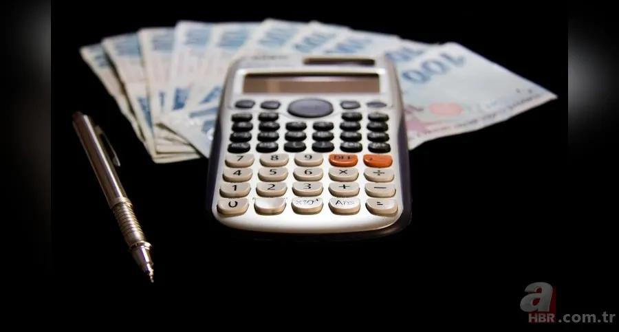 Türk lirası banknotları ve bir kalem yanında, siyah zeminde elektronik hesap makinesi duruyor.