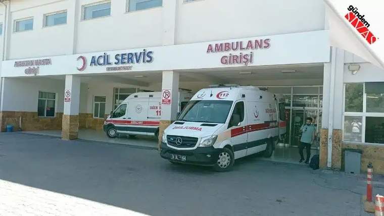 Acil servis girişinde iki ambulans duruyor, bir sağlık çalışanı görünmekte.
