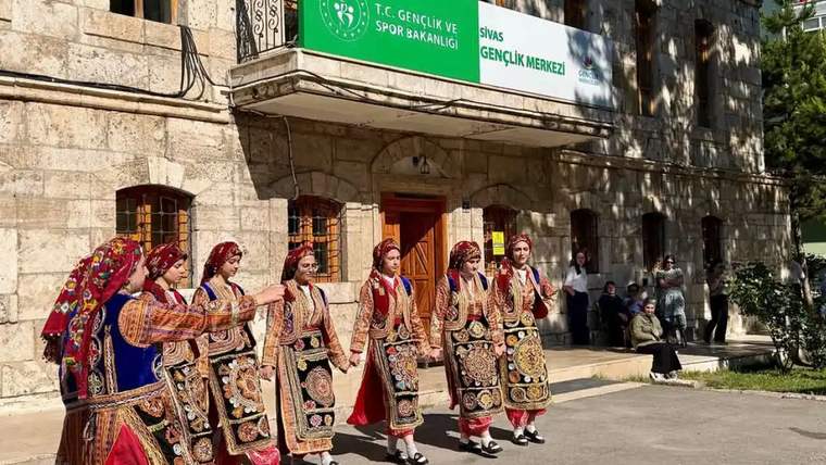 Halk oyunları kıyafetleri giymiş altı kişi, Sivas Gençlik Merkezi önünde gösteri yapıyor.