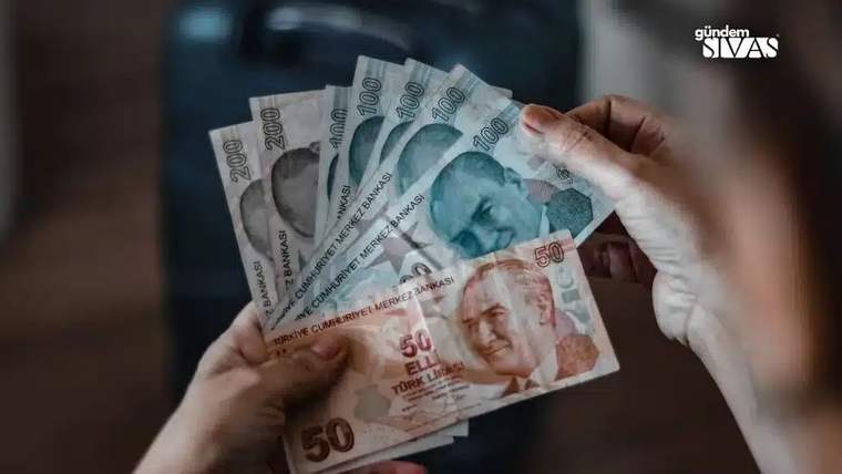 Bir kişinin elinde farklı değerlerde Türk banknotları var.