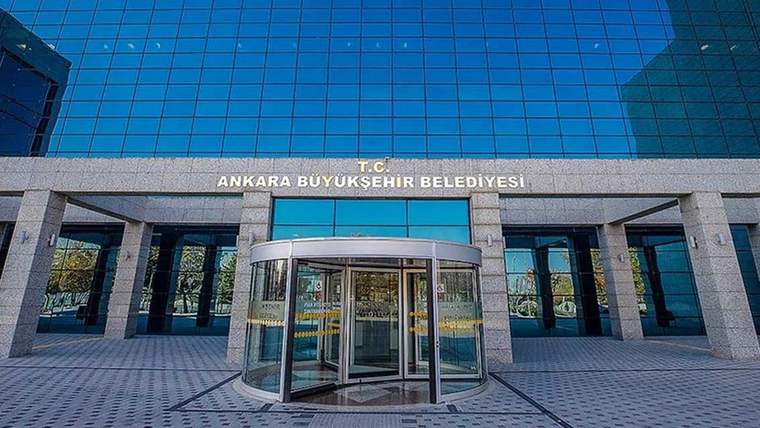Ankara Büyükşehir Belediyesi binasının ön cephesi, camlı kapı ve tabelası görünmekte.