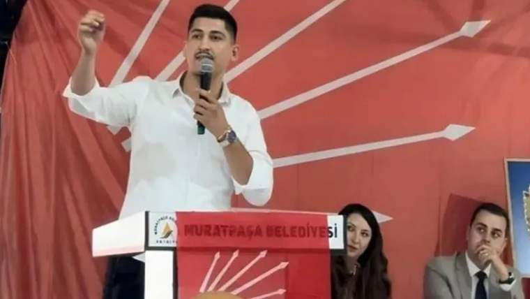 Kürsüde konuşan bir kişi, arkasında CHP logosu ve Muratpaşa Belediyesi yazılı bir tabela var.