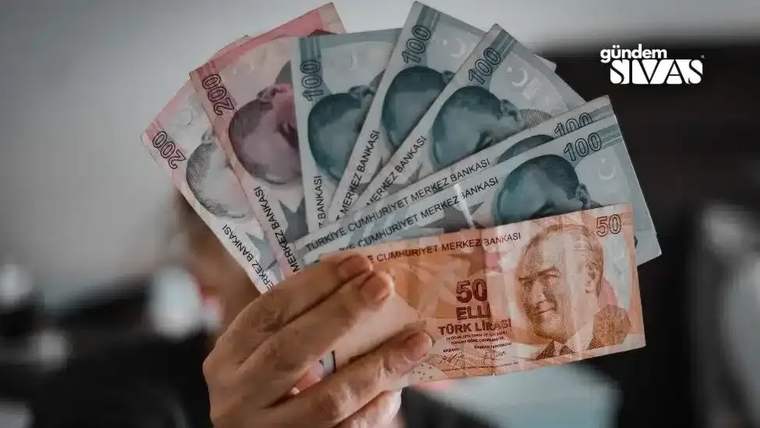 Bir el, farklı kupürlerde Türk lirası banknotlarını yelpaze biçiminde tutuyor.