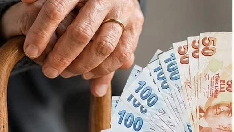 Bir kişinin elleri, üzerinde 100 ve 50 TL banknotların yer aldığı bir deste paranın üstünde duruyor.