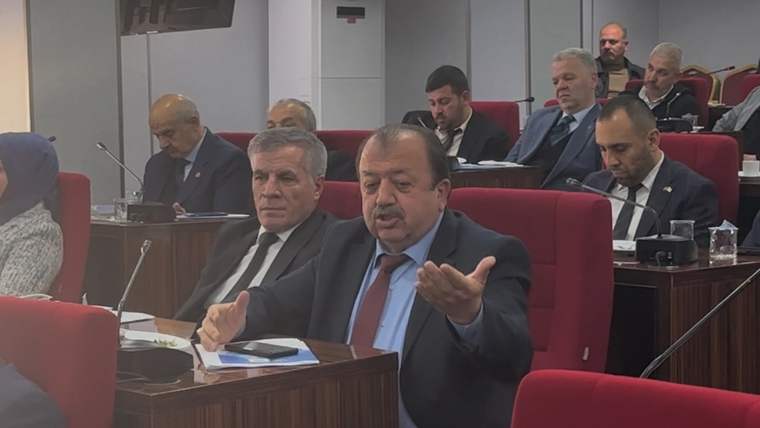 Isparta Belediye Meclisi'nde oturumda konuşan bir kişi, arka planda diğer meclis üyeleri yer alıyor.