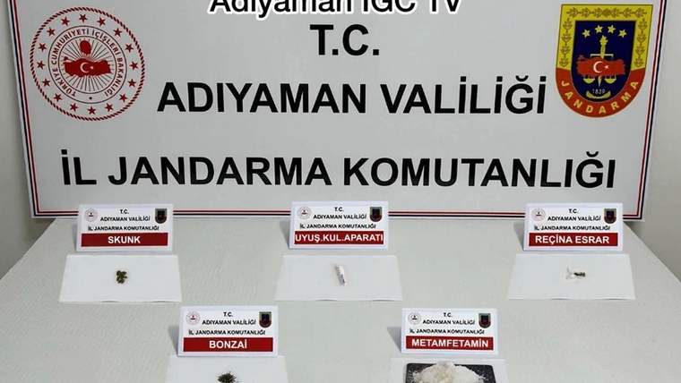 Adıyaman İl Jandarma Komutanlığı yazılı panonun önünde, etiketli beş numune ve küçük paketler sergileniyor.