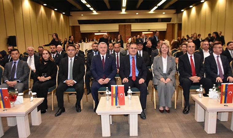 Toplantı salonunda önde oturan takım elbiseli kişiler ve masalarda Türkiye ile Moldova bayrakları görülüyor.