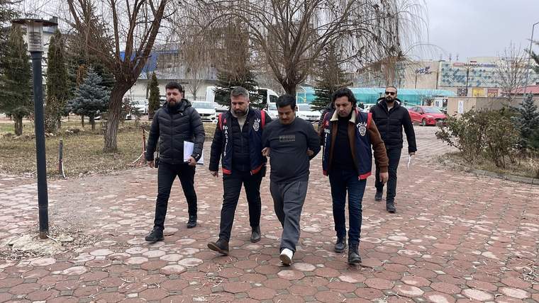 Ellerinden tutulan bir kişi, polis eşliğinde yürüyerek adliyeye doğru ilerliyor.