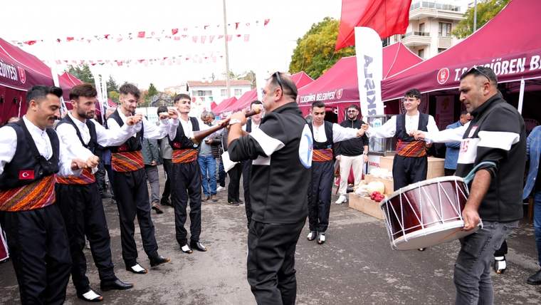 Keçiören Fatih Stadı'nda geleneksel kıyafetler giymiş grup, müzik eşliğinde dans ediyor.