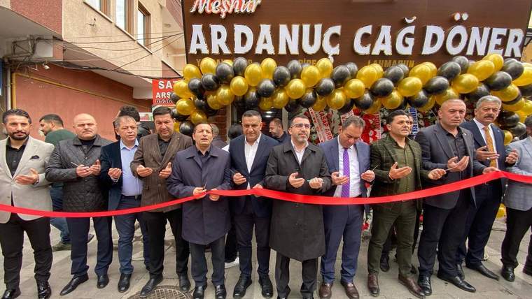 Üzerinde “Meşhur Ardanuç Cağ Döner” yazan tabelanın önünde, kırmızı kurdeleli kalabalık duruyor.