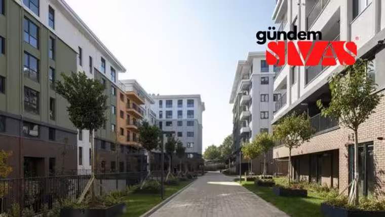 Modern apartman binalarının bulunduğu bir konut kompleksi, yeşil alanlar ve ağaçlarla çevrili.